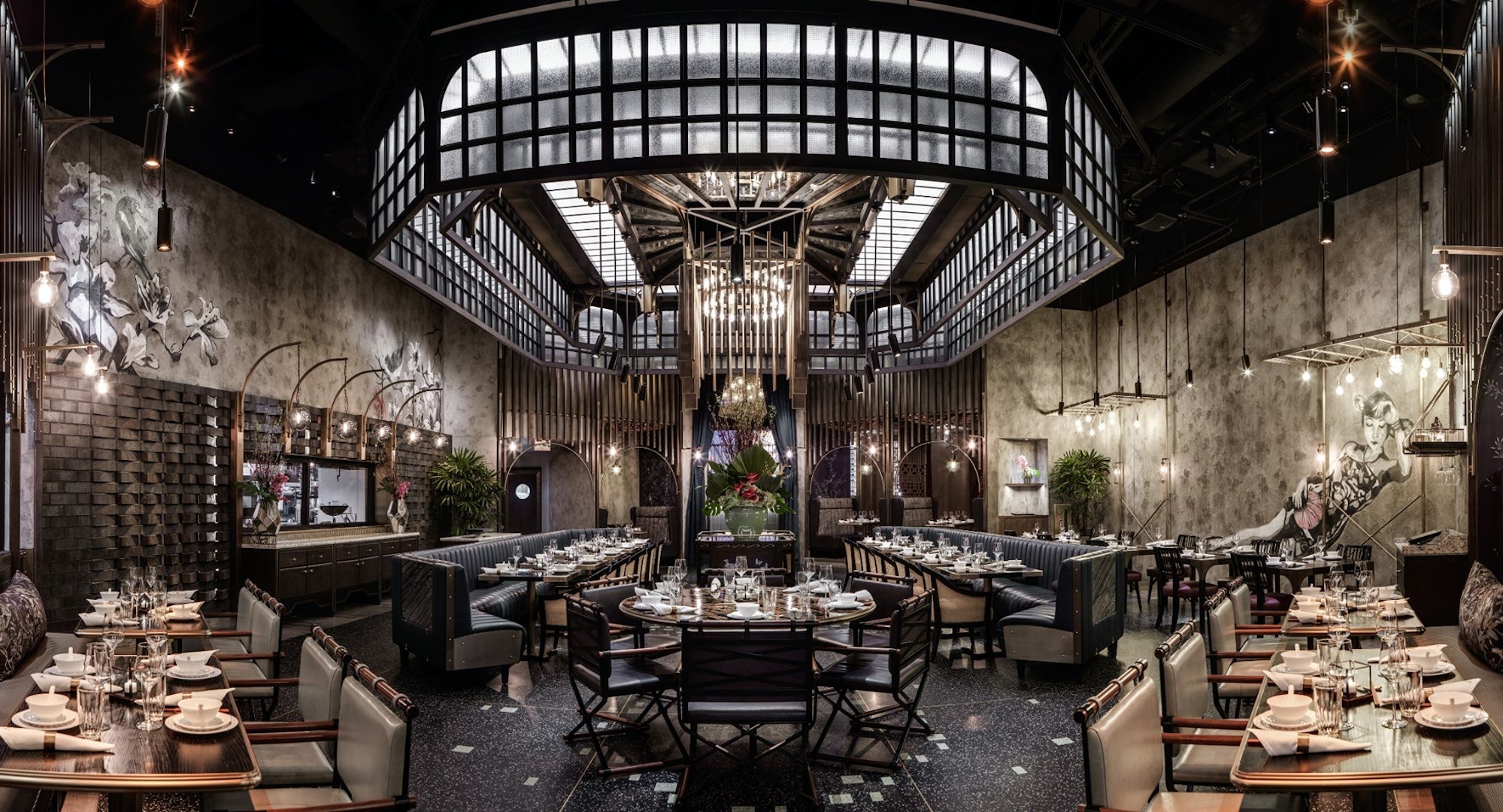 Internal shot of a restaurant with moody decor and a large glass light on the ceiling