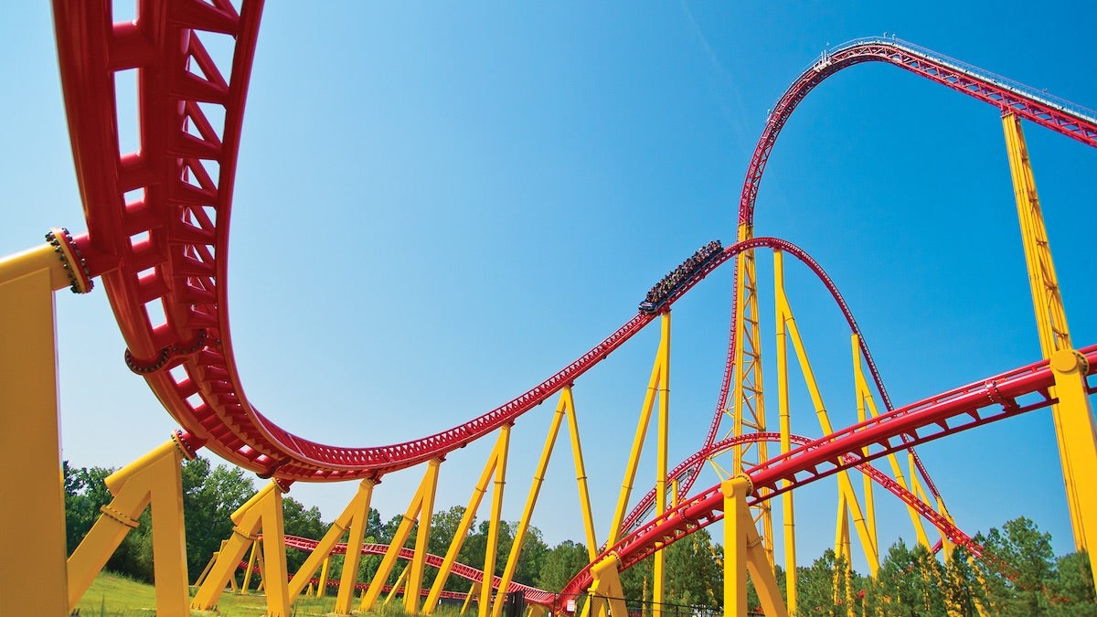 Red and yellow roller coaster under a blue sky at Kings Dominion