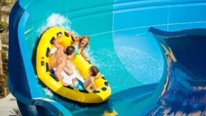 Family on a yellow tube sliding along a blue water slide