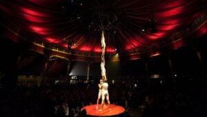 Four men performing acrobatics under a red tent ceiling at Absinthe in Las Vegas