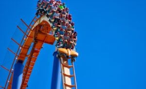 Roller coaster with riders under a blue sky