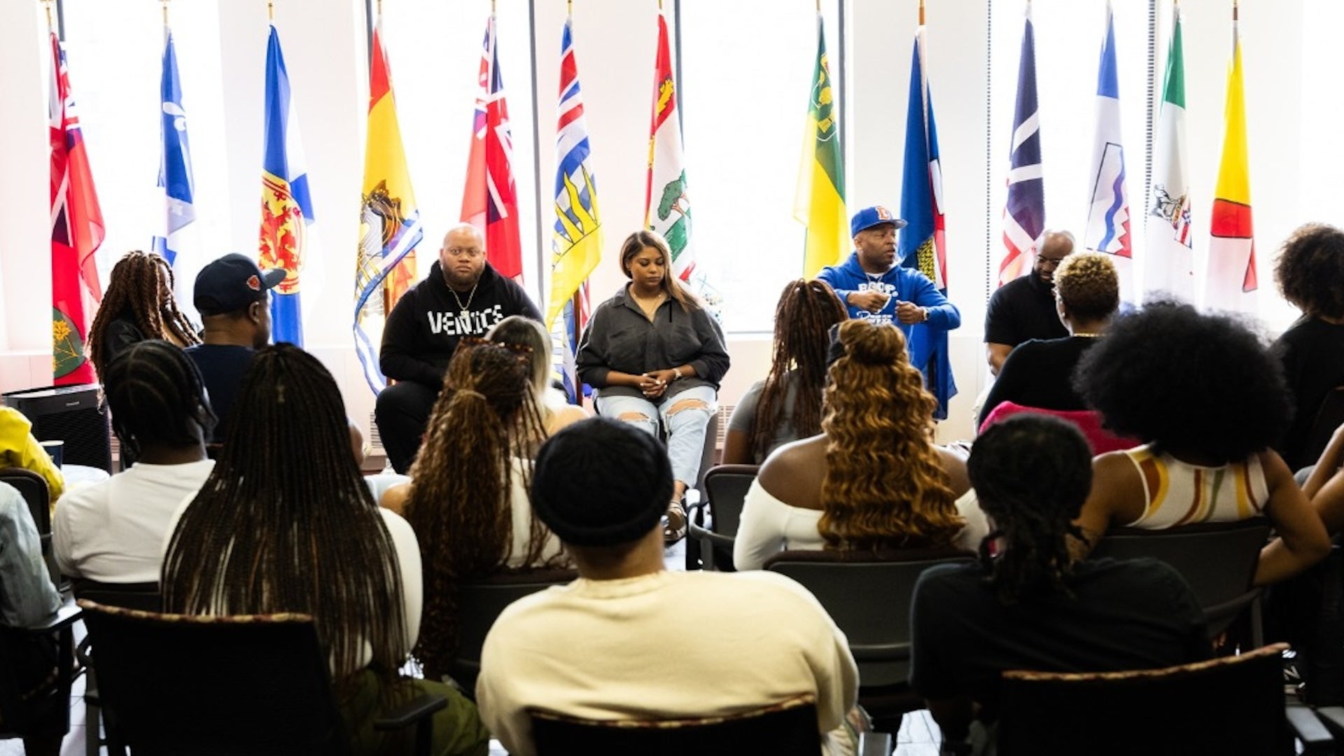 people meeting with flags behind the chairs