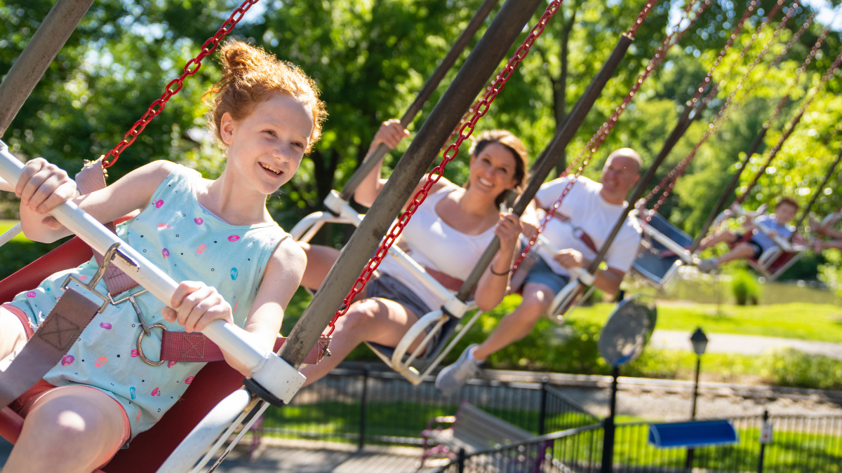 Kids smiling and enjoying a swing ride at Dutch Wonderland