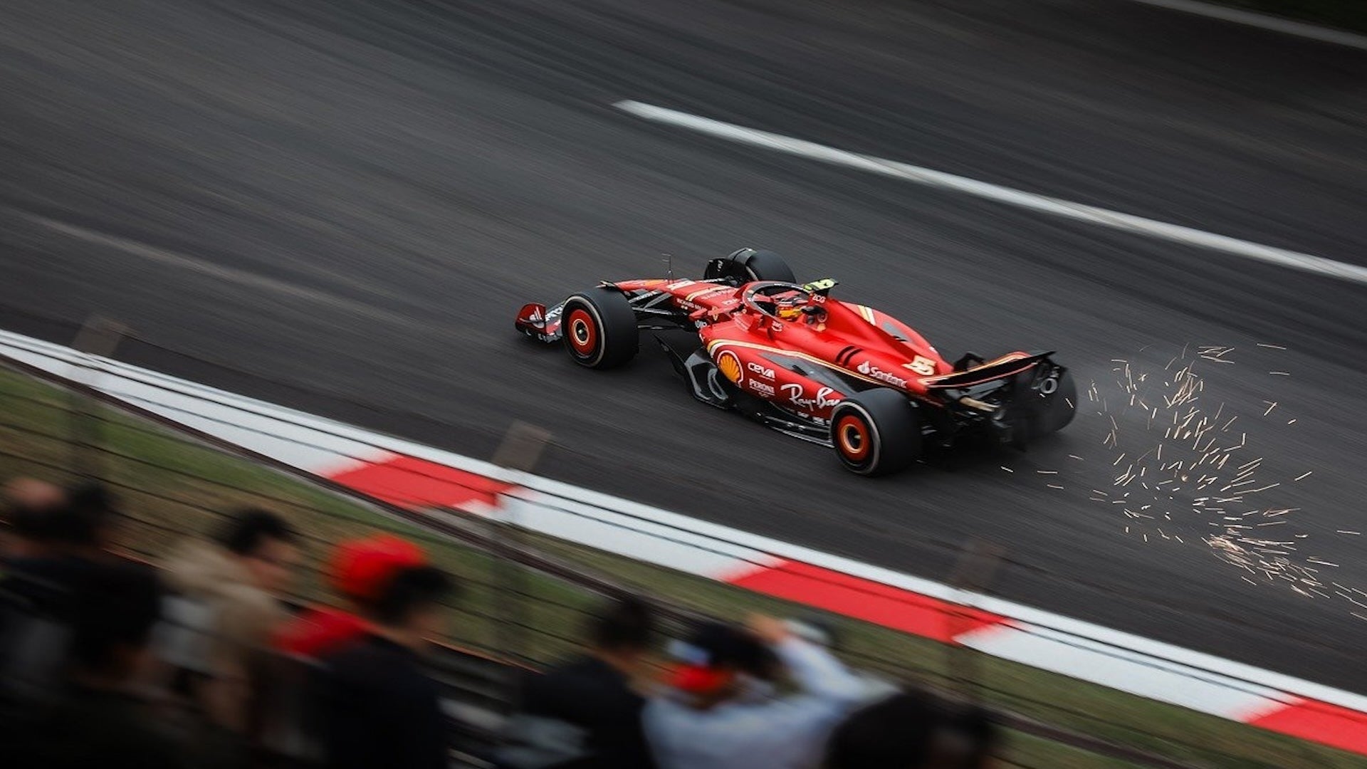 red sportscar on the move while audience watching