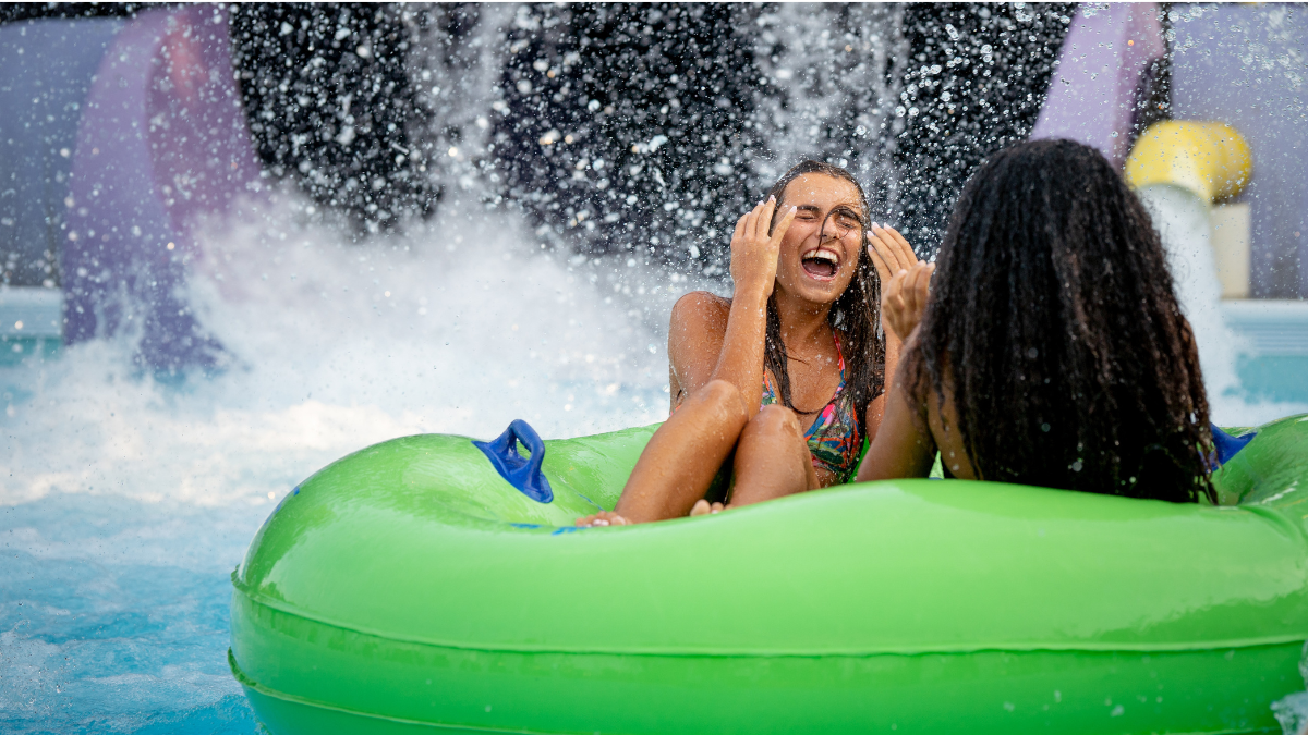 Two girls laughing and enjoying the water in a pool at Splish Splash Water Park.