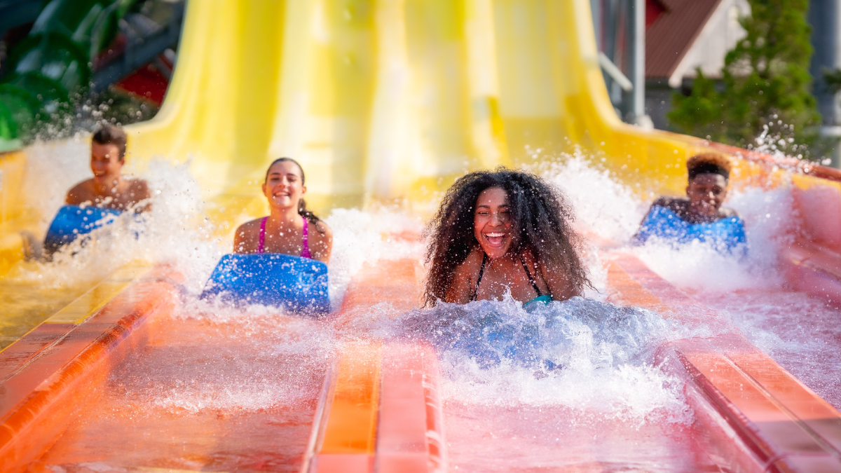 Group of friends racing down water slides at Splish Splash Water Park.