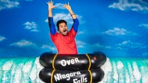 Man pretending to go over Niagara Falls with his hands up at Louis Tussauds Waxworks