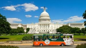 hop on hop off-tour all day bus in front of a white building