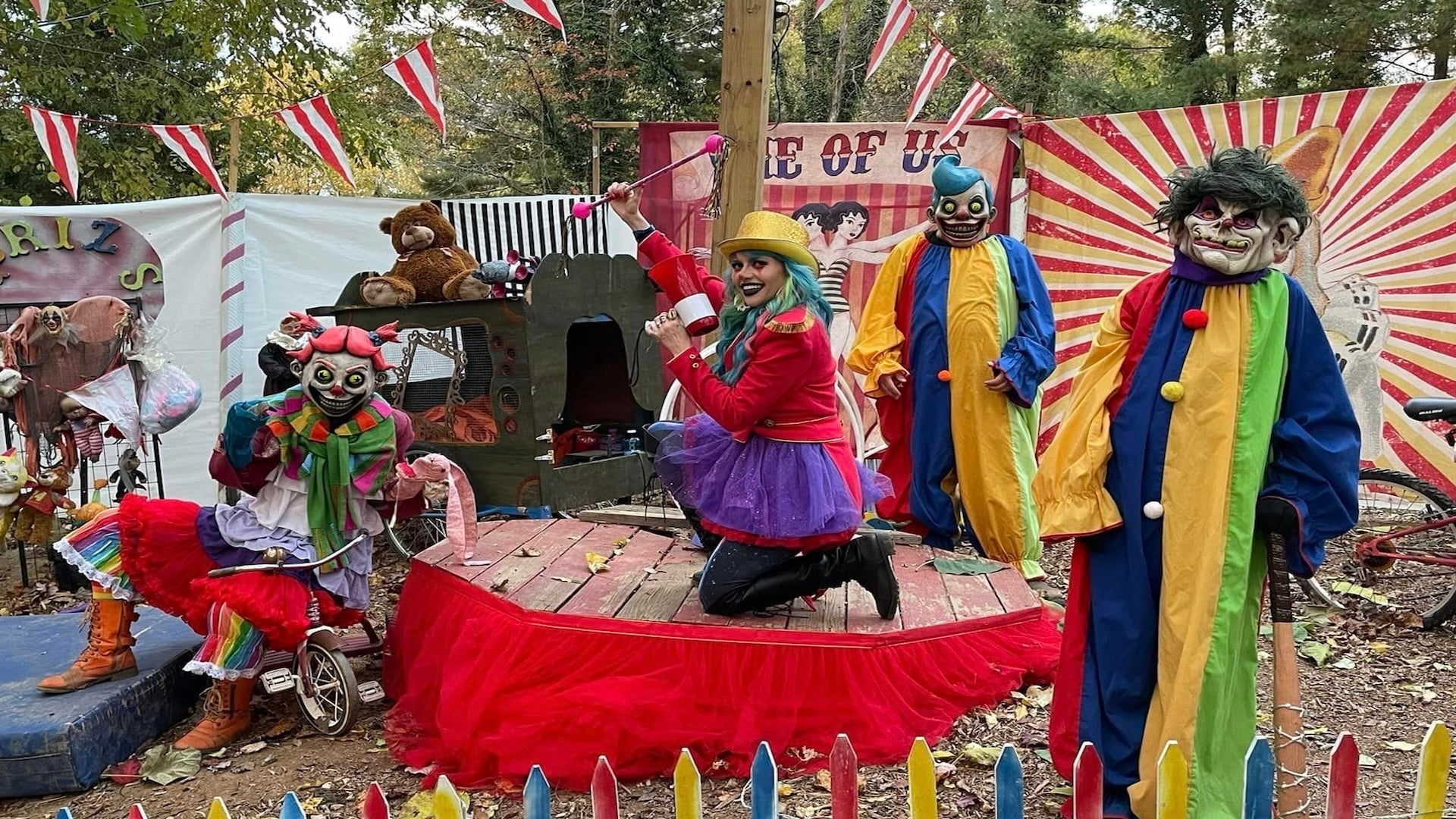 three clows statues with a woman posing at The Haunted Trail