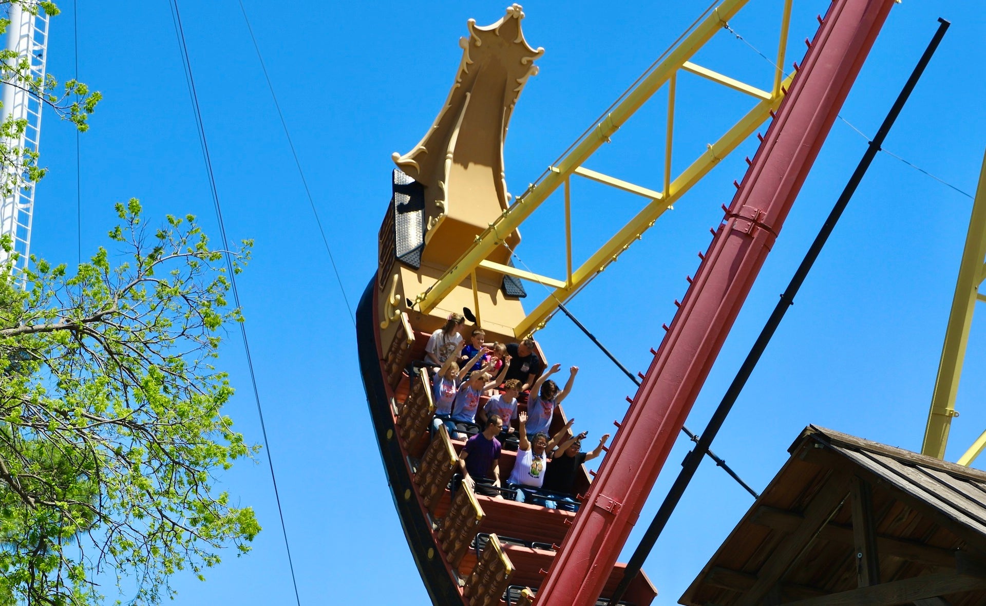 Theme park ride with people on it under a blue sky