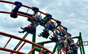 roller coaster with people on it under a cloudy sky