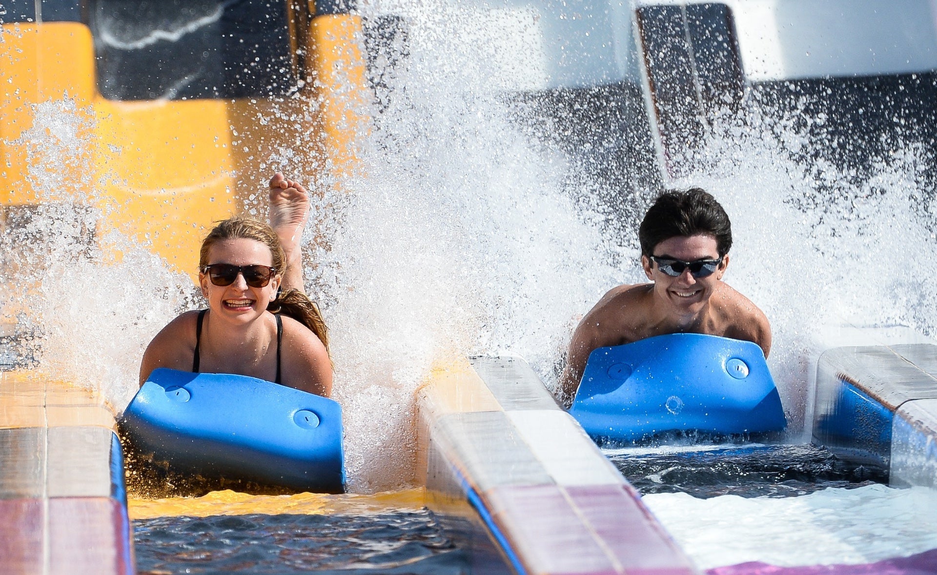 Two people on blue slides at a water park