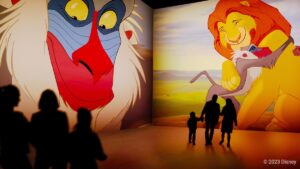 Lion king projected largely on walls as people look at it