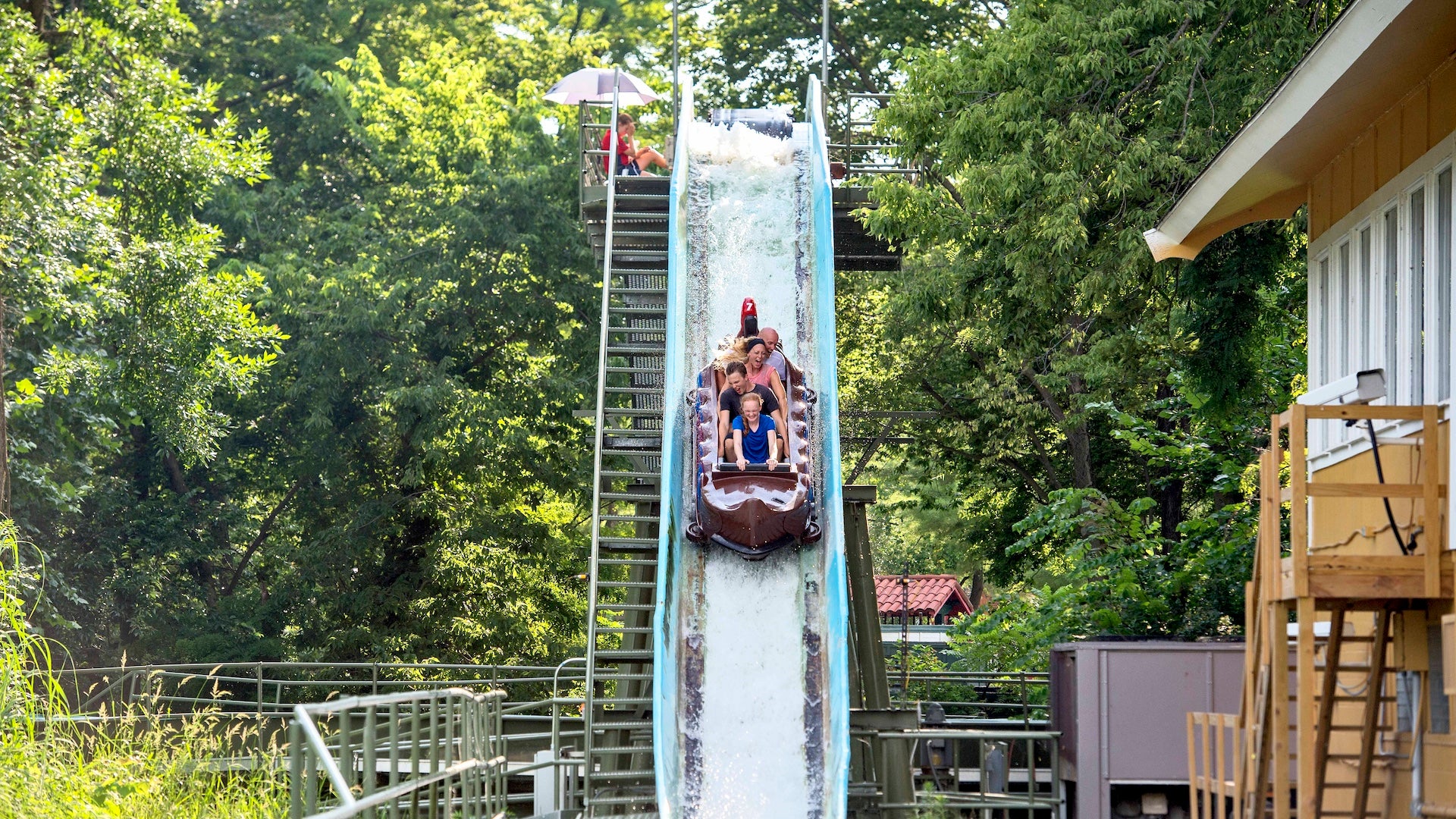 People riding on a water ride going down a hill