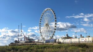 Ferris wheel on a boardwalk under a blue sky