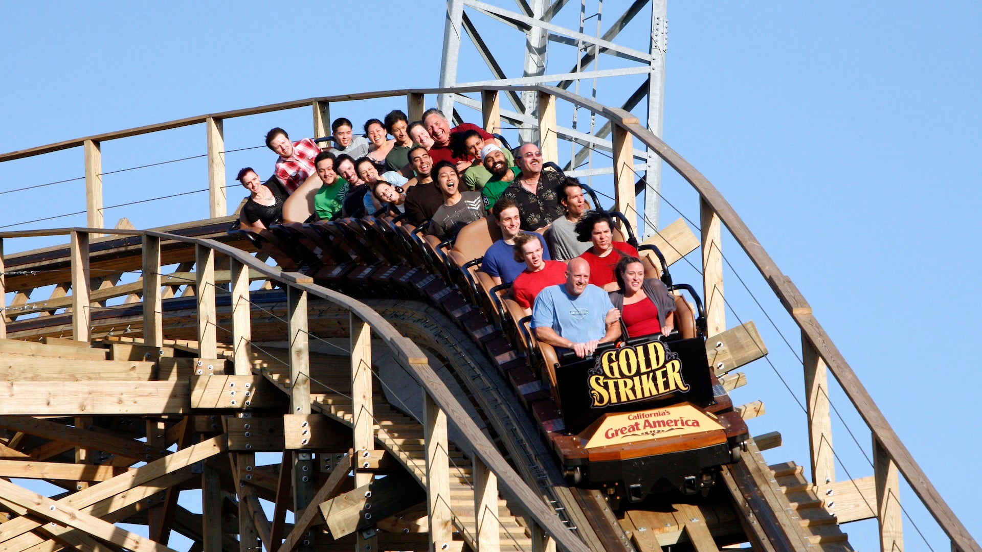 Riders in a car on a wooden roller coaster