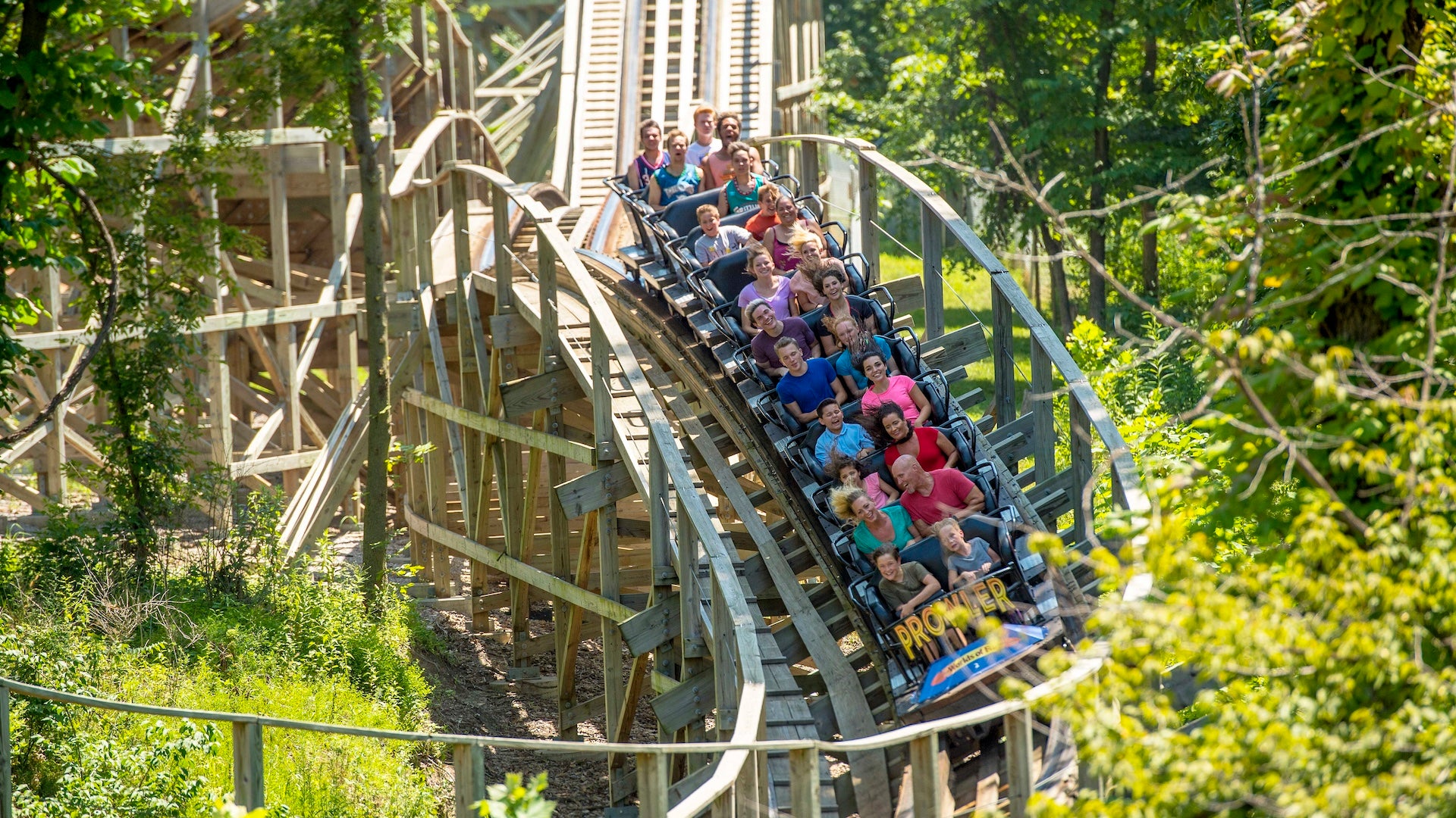 People riding on a wooden roller coaster at Worlds of Fun