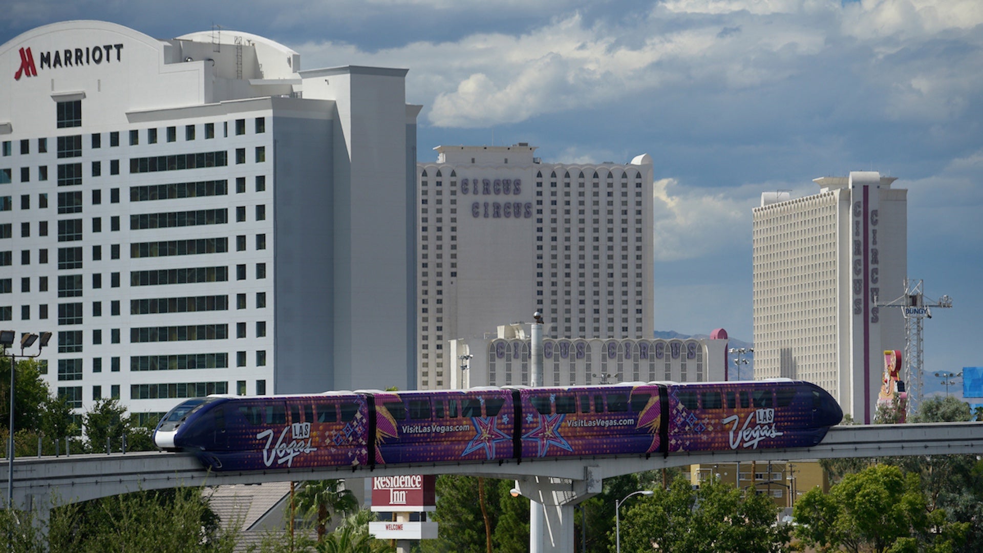 A Las Vegas Monorail train in a "VisitLasVegas.com" wrap travels by the Las Vegas Convention Center