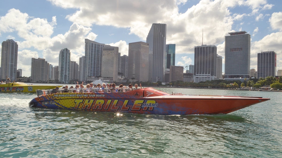 Red and yellow thriller speedboat in the water with Miami skyline in the background