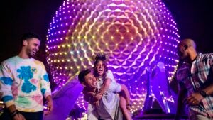 Spaceship earth at night with people in front of it