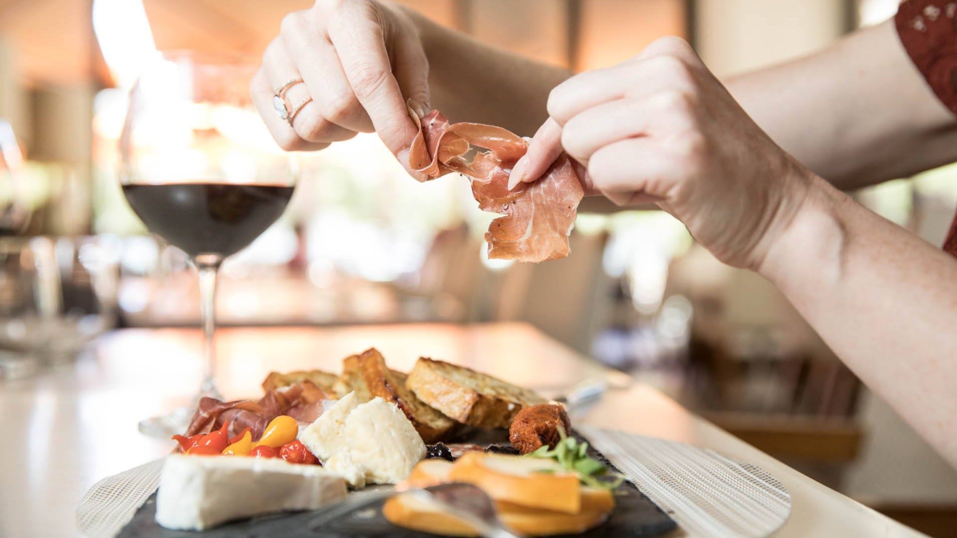 meat, wine, platter held by a woman at Alexxa's Paris Hotel