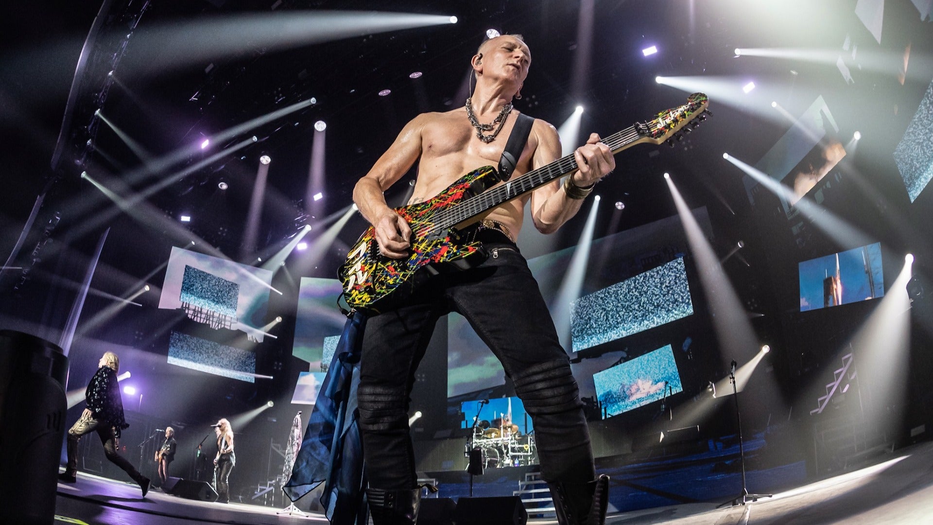 Def Leppard rock band performing on stage with electric guitar