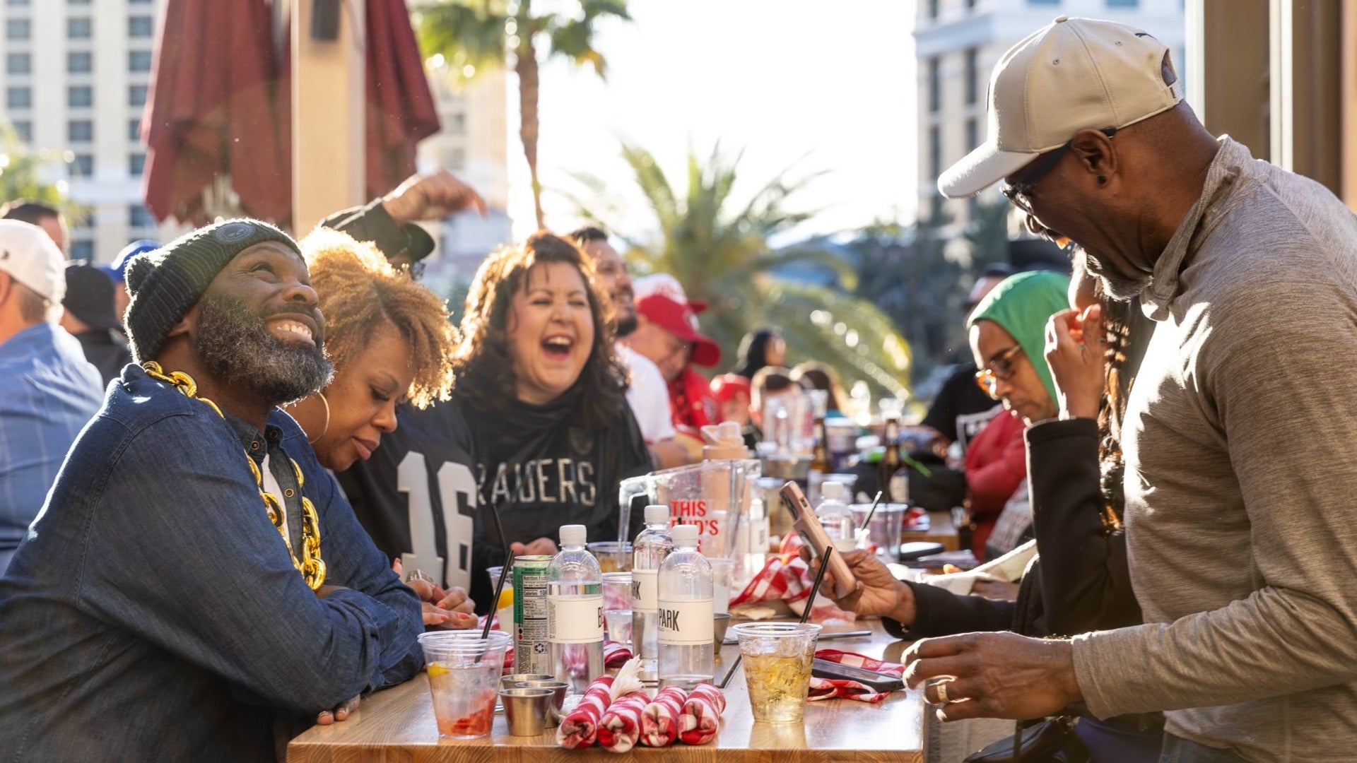 group of people having fun over drinks, sunset at beer park, paris hotel las vegas, alcohol and water on the table