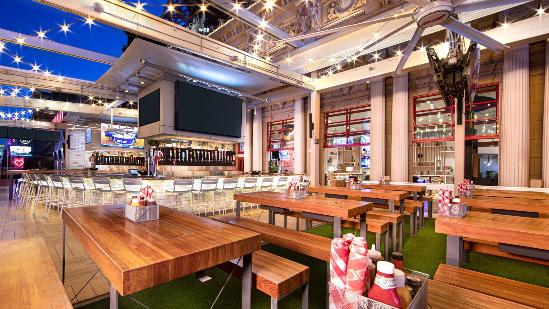 tables, chairs, bar and interior of beer park, paris hotel las vegas, string lights