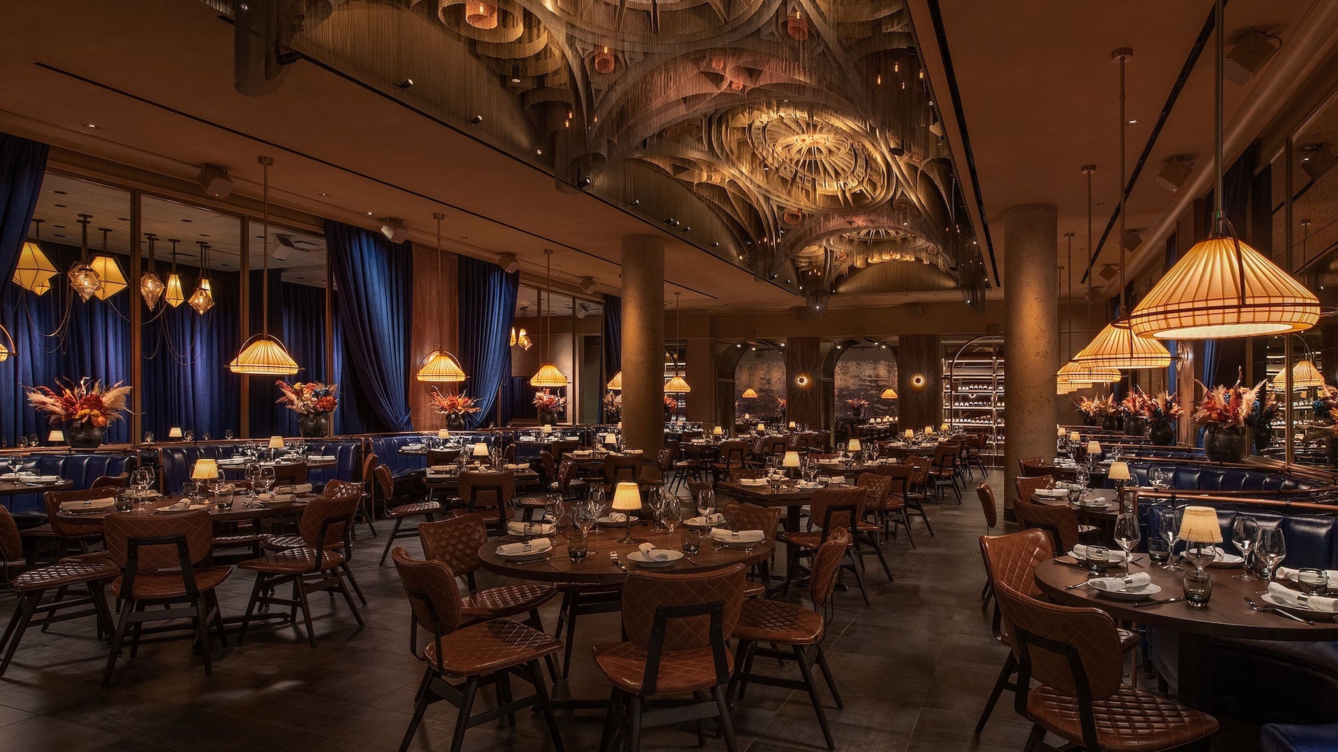 Interior of a dining room with a gorgeous cathedral style ceiling and wooden tables with leather chairs