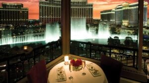 romantic candlelight dinner table at eiffel tower restaurant with a view of the bellagio fountains, sunset