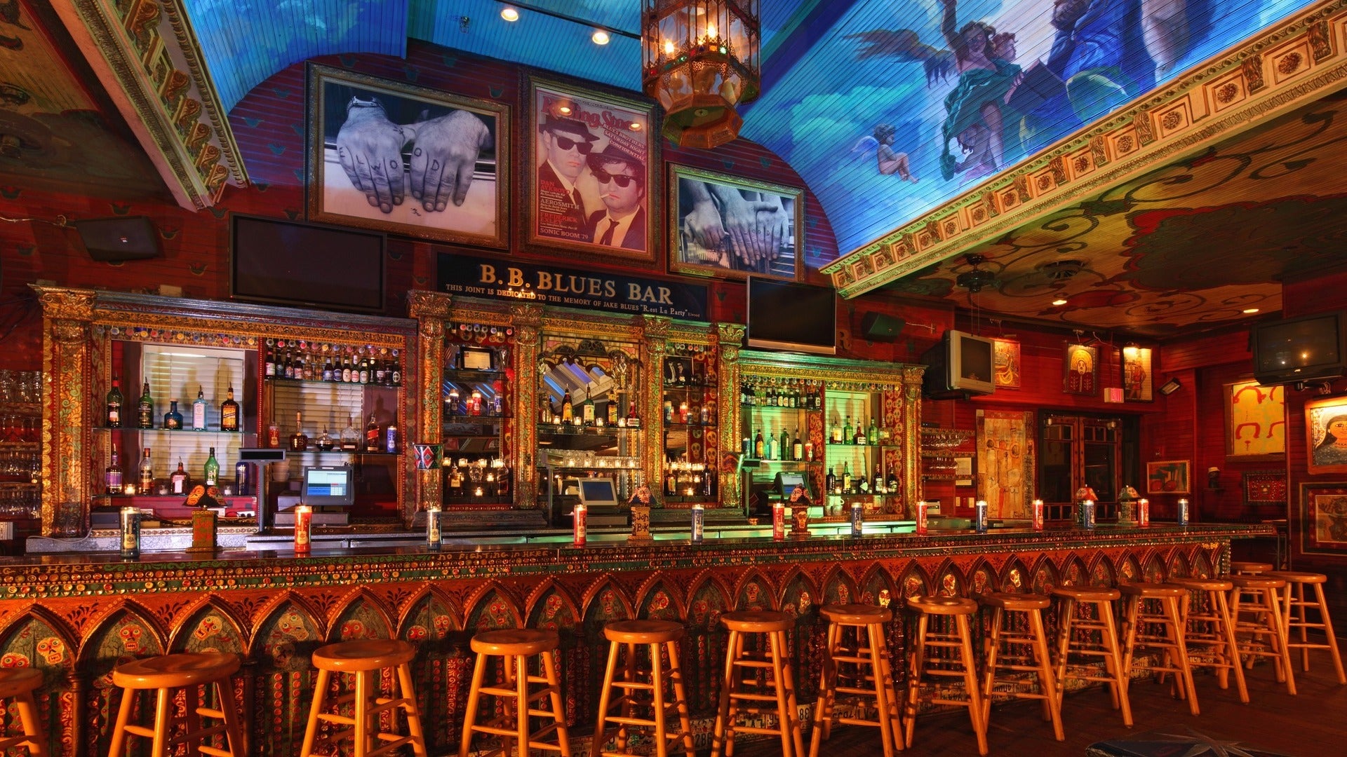 bar with counter and bar stools, alcohol displayed at the back