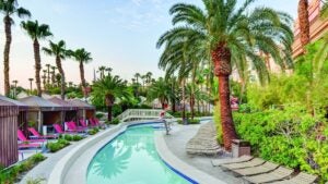 Lazy river with palm trees and cabanas with pink lounge chairs at Mandalay Bay in Las Vegas