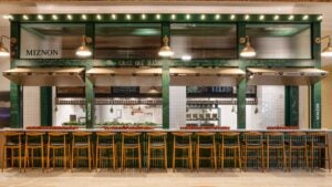 restaurant exterior with bar stools and kitchen at the back