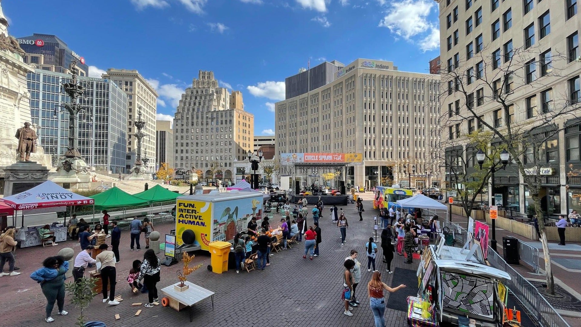 circle spark fair with people visiting booths, view of monument in the back