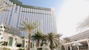 exterior of park mgm hotel during daytime, with palm trees and pool umbrellas