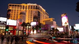 planet hollywood hotel exterior at night, cars passing by and people crossing