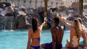 group of people enjoying drinks at a pool on a sunny day