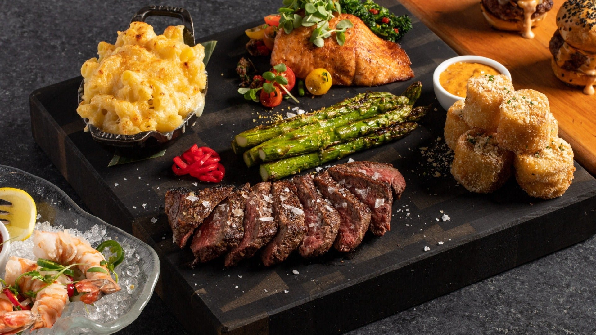 stk steakhouse mac and cheese, steak, with asparagus and sides on a serving board