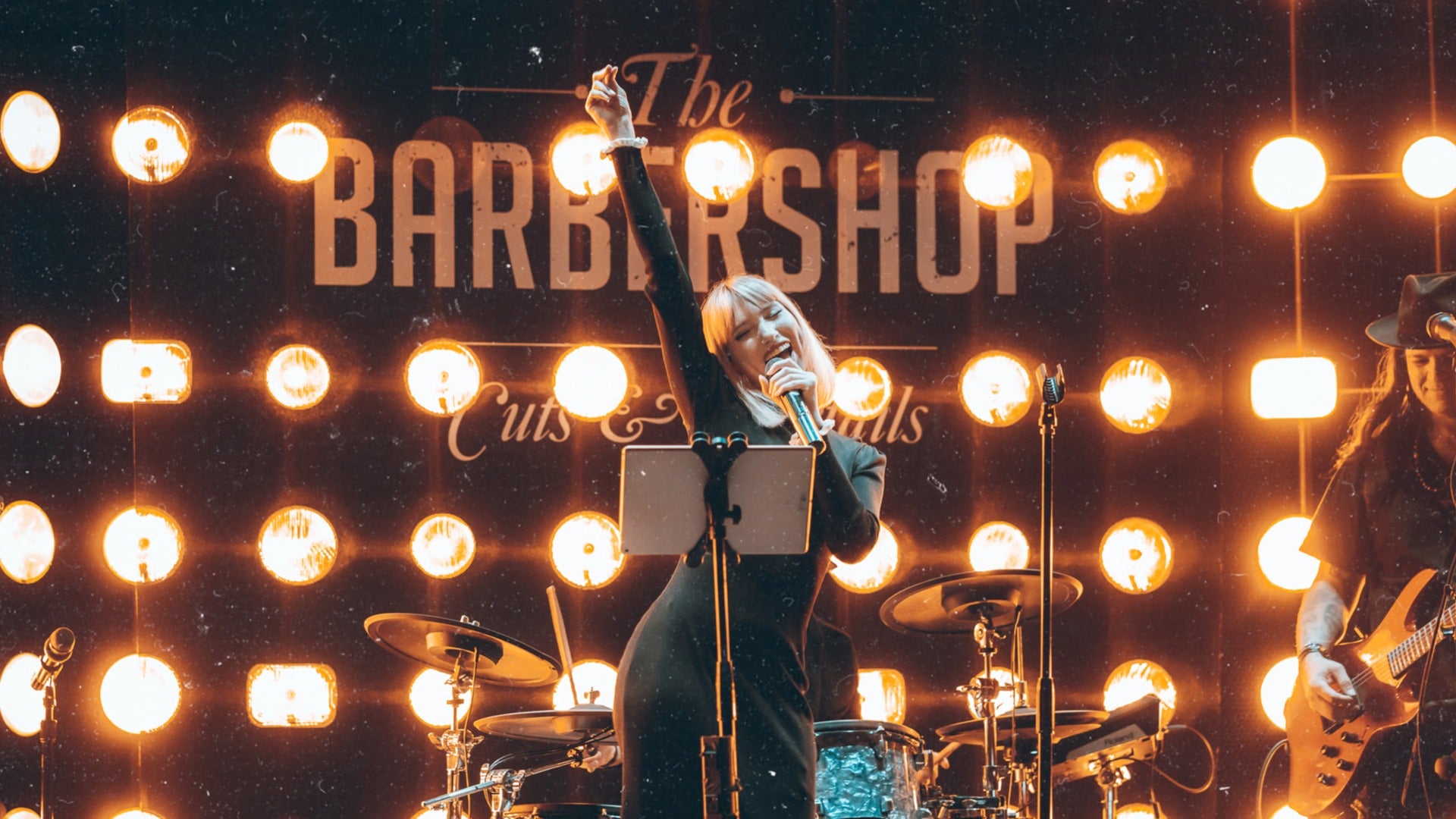 woman singing on stage with lights at the barbershop cuts and cocktails in cosmopolitan hotel las vegas