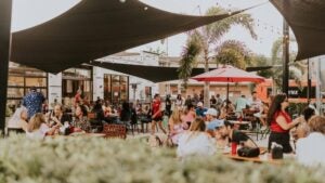 Groups of people eating and having fun, waitress, outdoor umbrellas