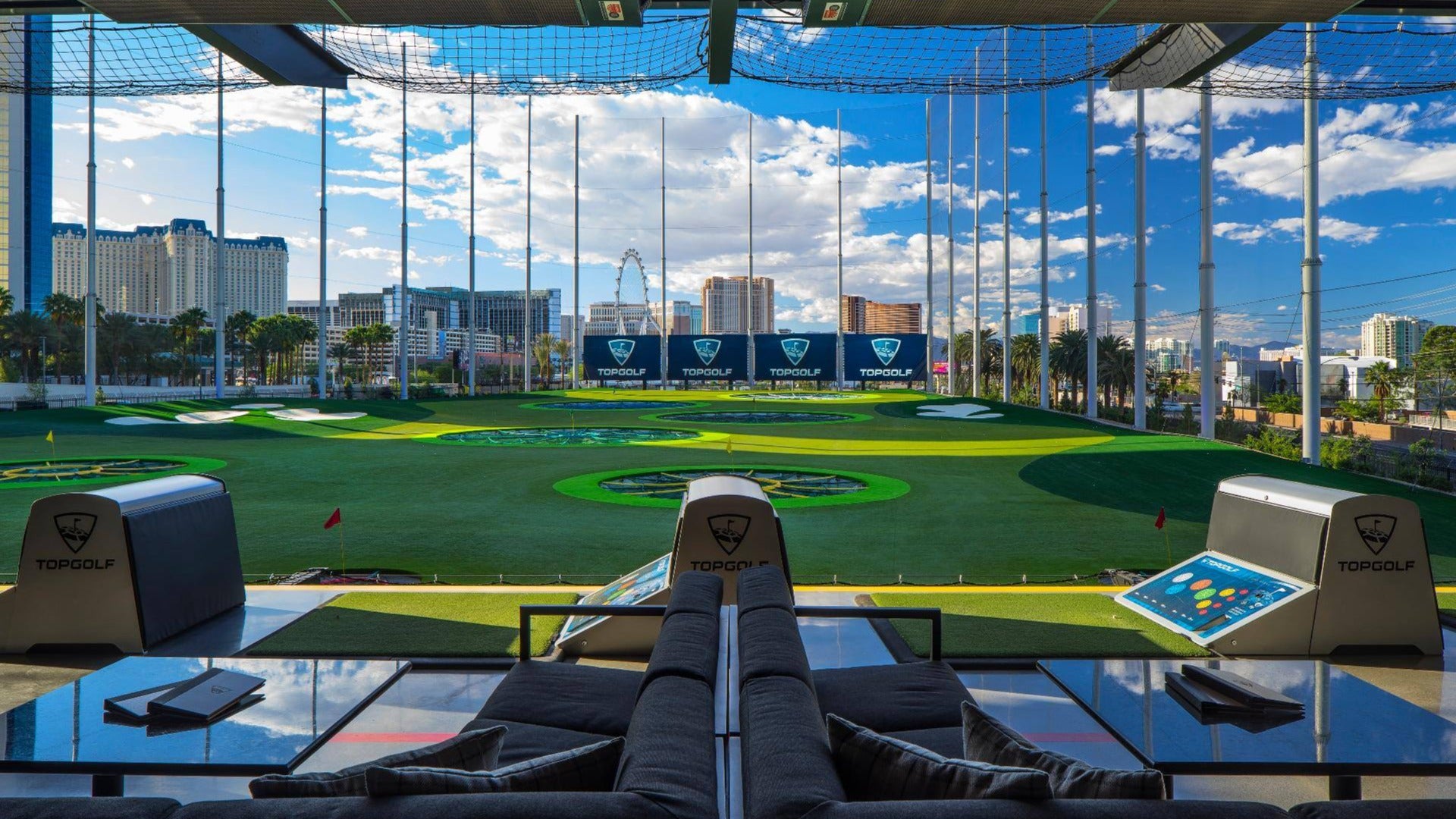 golfing spot, hitting bays, with seats and las vegas skyline at the back