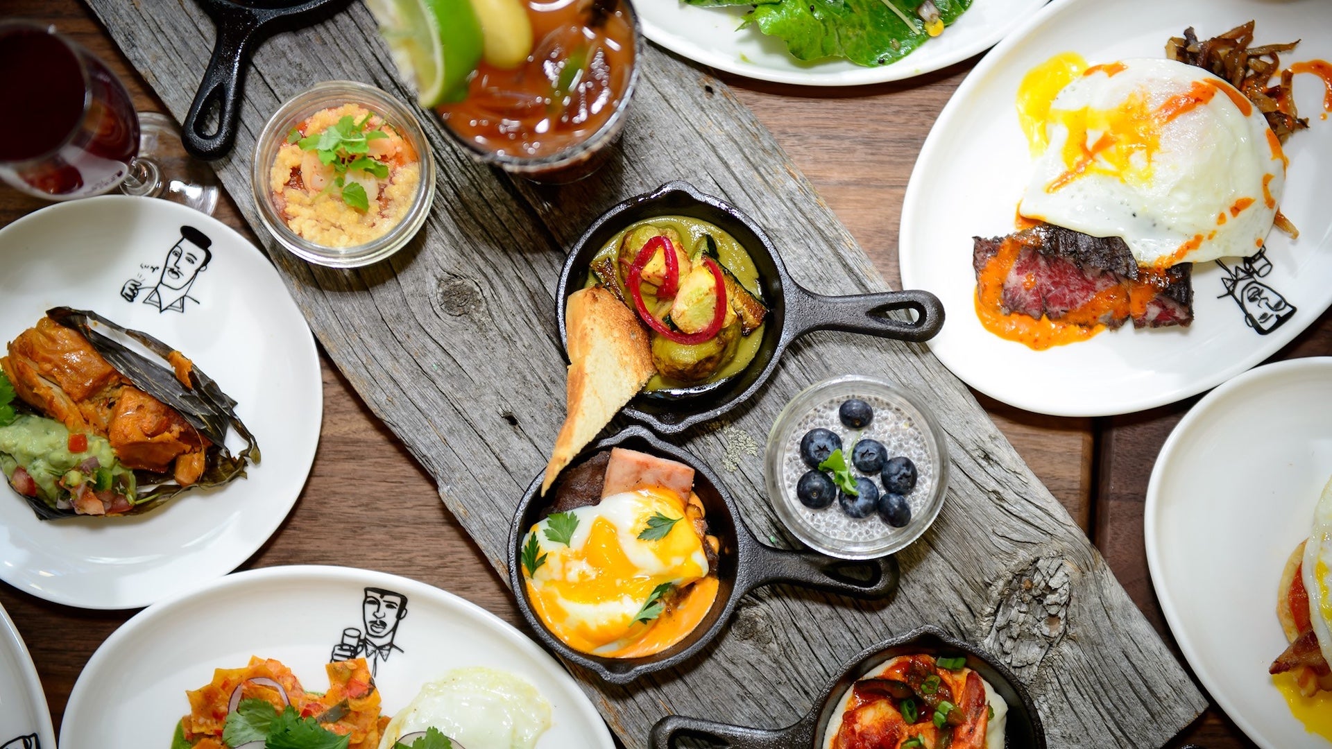 Several plates of food on a wooden table