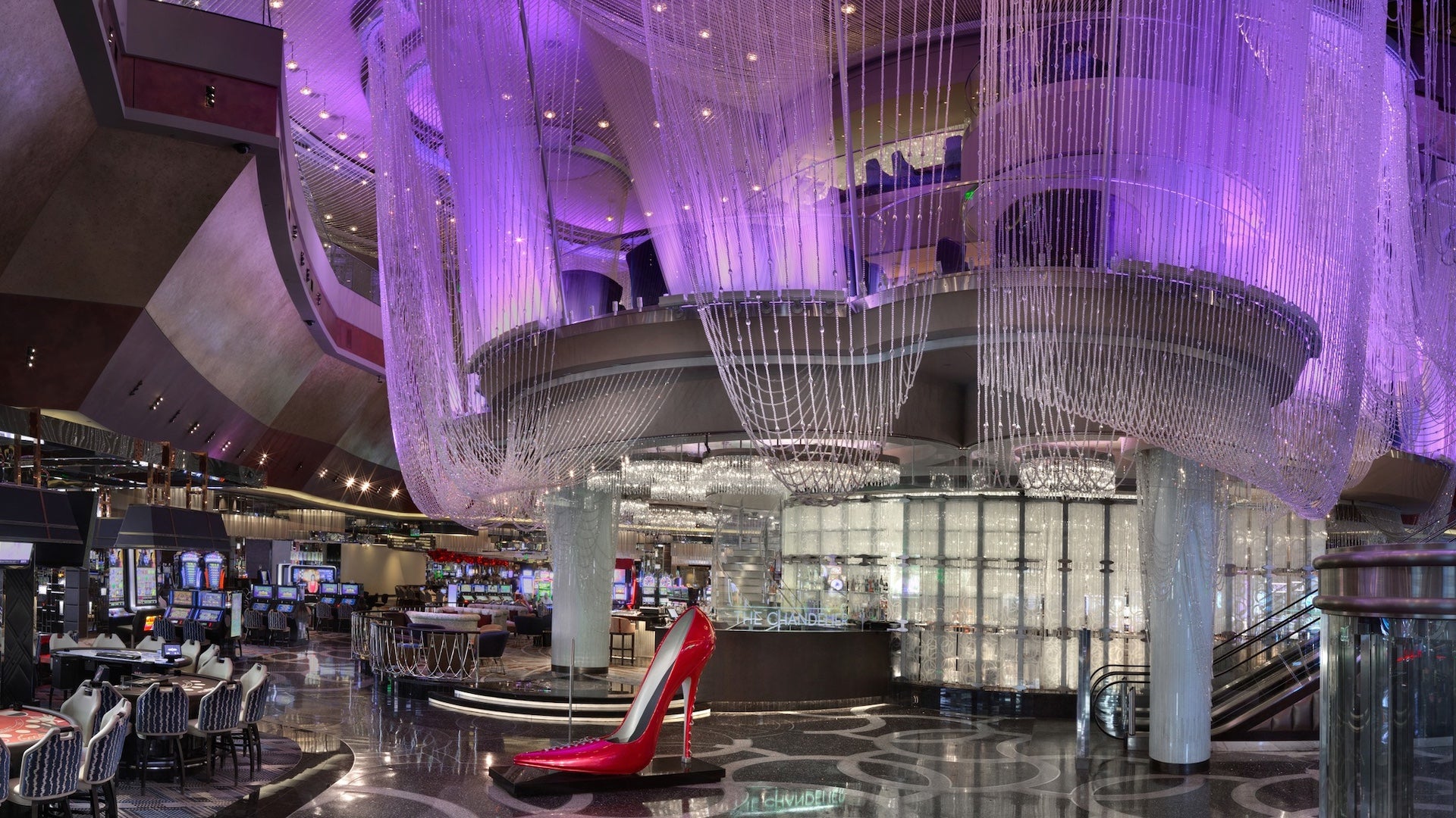 Chandeliers hanging from the ceiling on the bar's first level with a giant red shoe