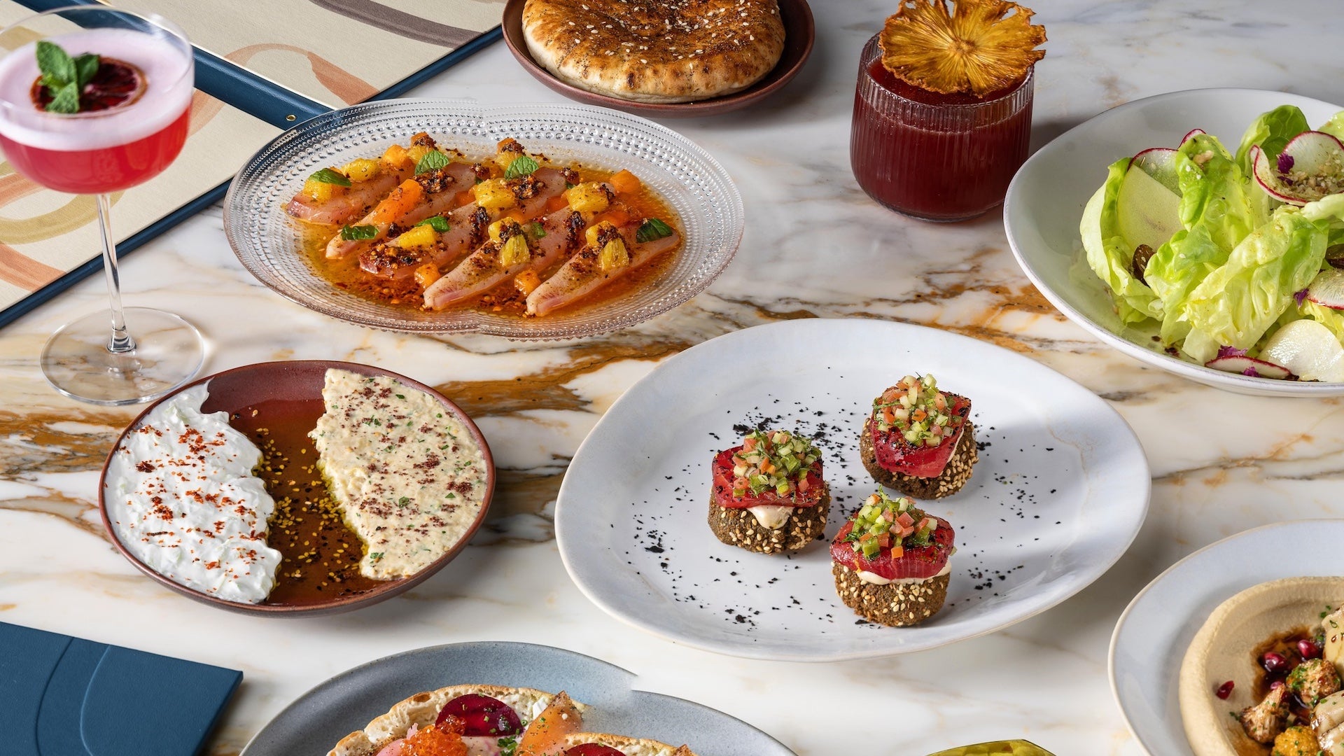 Several plates of food on a marble table