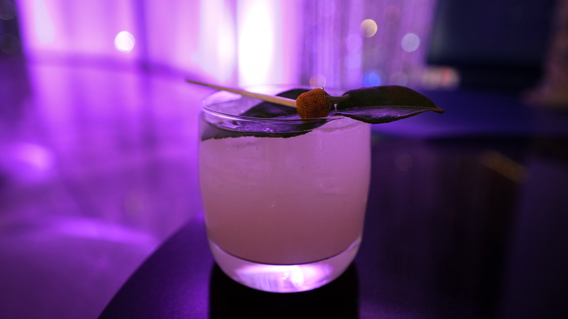 A cocktail with purple backlighting