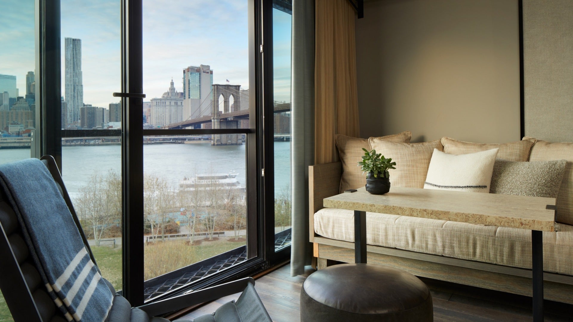 hotel room view of brooklyn bridge with a seating area