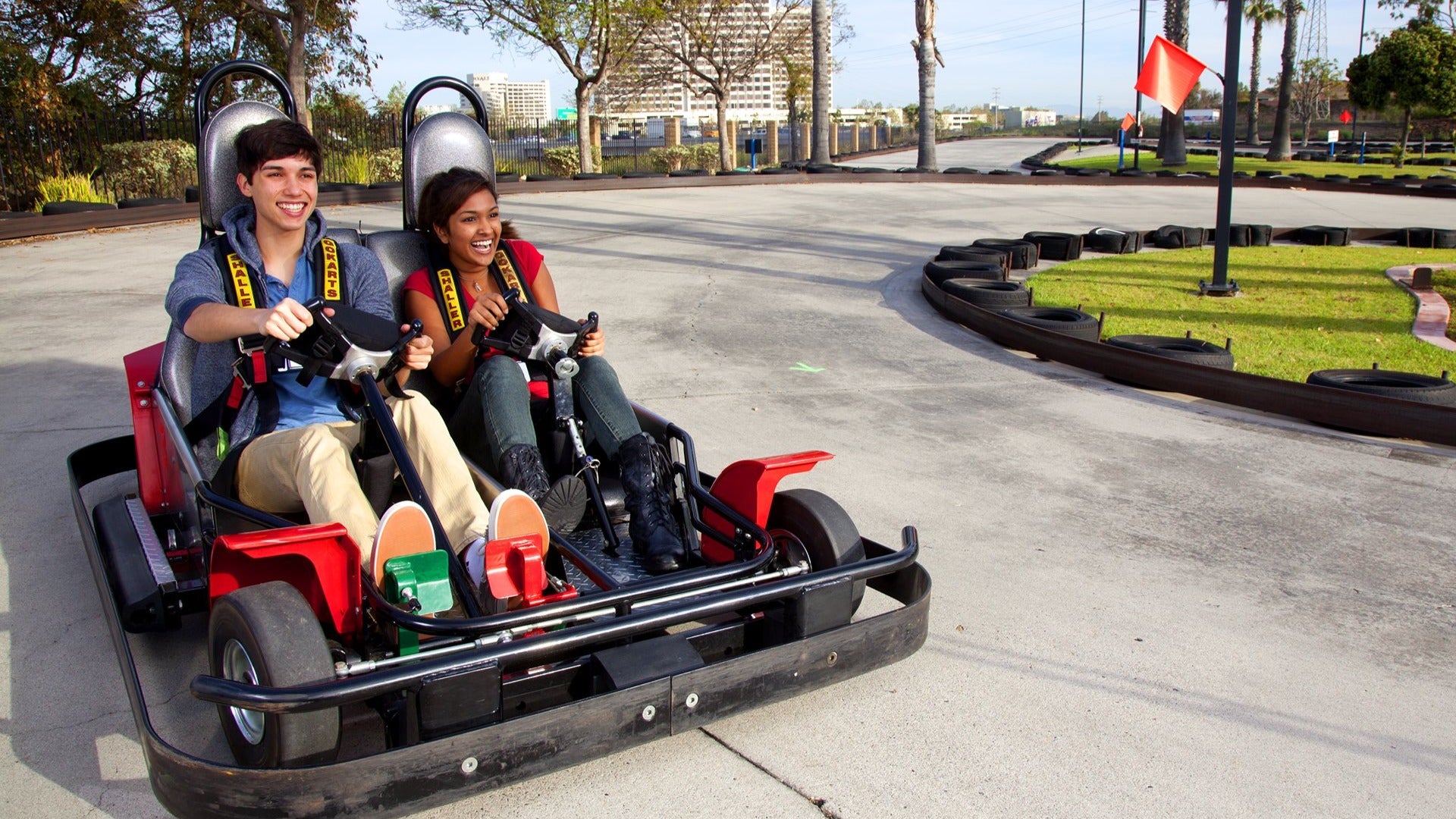 two people riding a cart in a race track