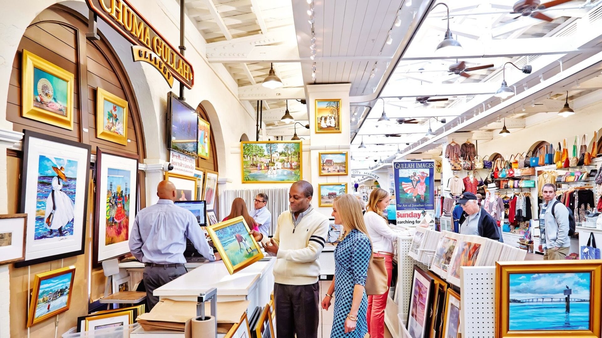 people looking at paintings at a market, shopping, bags and clothes on shelves at the side