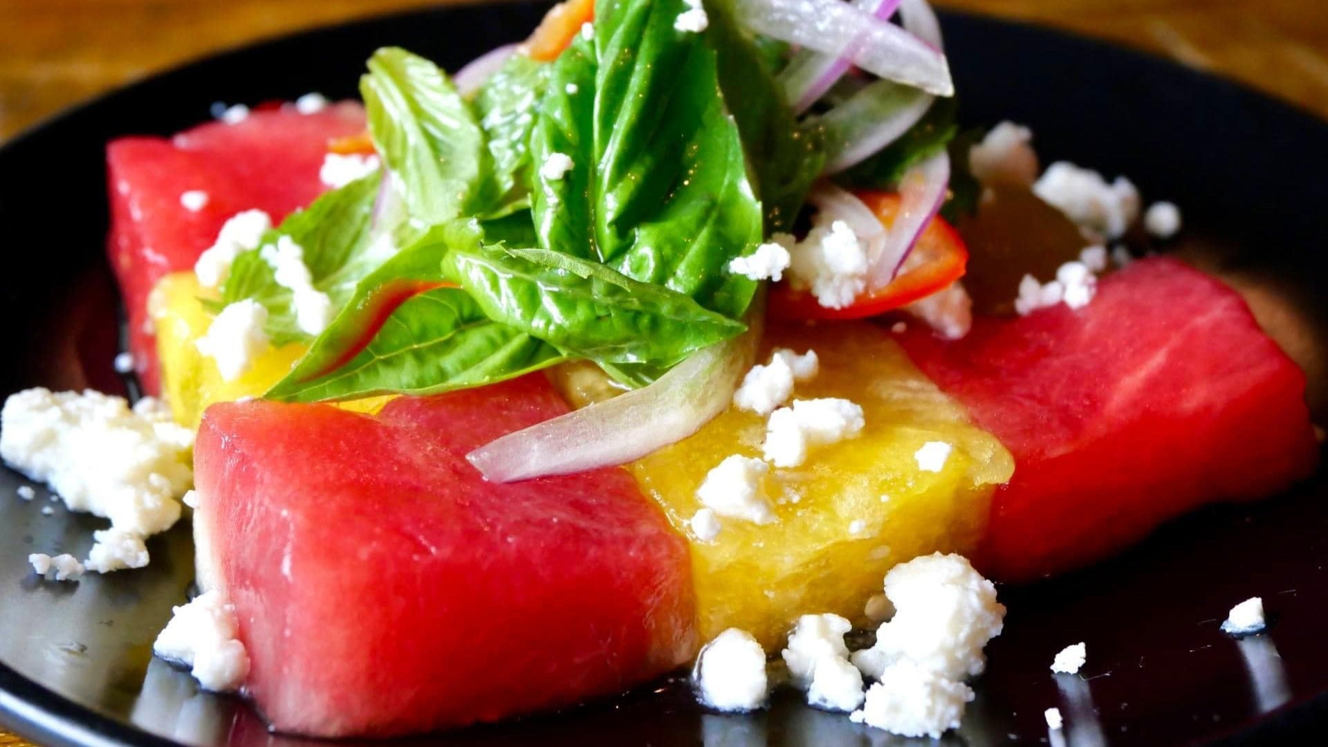 tapas style plate with watermelon, herbs, and other ingredients