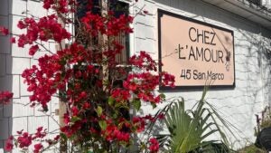 restaurant exterior with signage and flowers beside the window